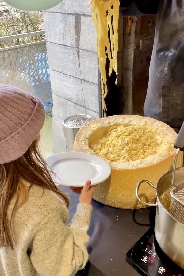 Tagliatelle rolled in the parmesan wheel and served in the room.
