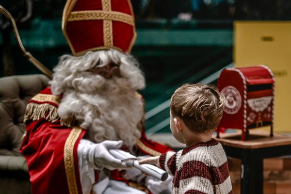Saint Nicholas handing over a present at the Saint Nicholas brunch.